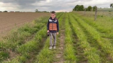 Tarladaki köpeklerden kaçan bir çocuk. Köpeği gezdiriyorum. Arkadan bak. Köpekli Mutlu Çocuk. Yüksek kaliteli FullHD görüntüler
