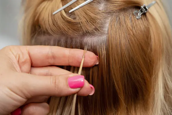 Bir tutam sarı saç eklentisi. Saç stili değişikliği. Güzellik salonu. Yüksek kalite fotoğraf