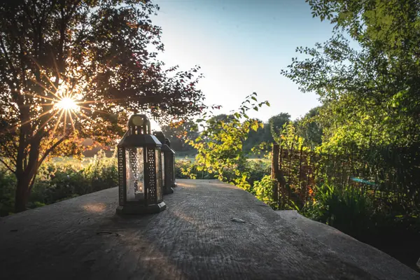 Kamp alanındaki ahşap bir masada yağ ve mum feneri..