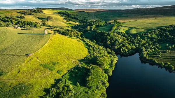 Yorkshire 'ın ücra bir köşesindeki gölle çevrili tepenin üstünde küçük bir kule.
