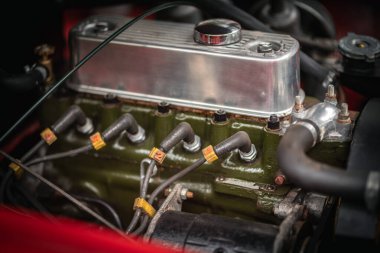 Otomobil motorunun fındık, vida ve metal parçaları gibi kıvılcım tıkaçları ve otomotiv mühendisliği gibi çeşitli otomotiv parçaları içeren detaylı bir görüntüsü