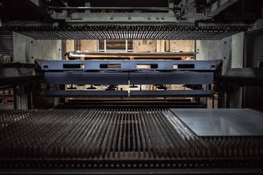 Fabrikanın içindeki metal levha endüstriyel vakum aletleri kaldırıyor..