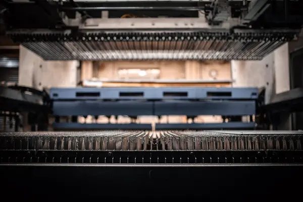 Fabrikanın içindeki metal levha endüstriyel vakum aletleri kaldırıyor..
