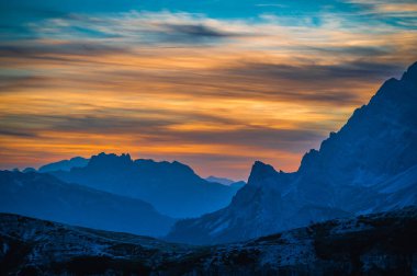 The Tre Cime di Lavaredo also called the Drei Zinnen are three distinctive battlement-like peaks at sunset 