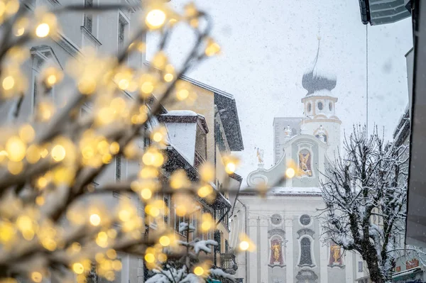 stock image close-up shot of tree with Christmas lights on snow covered street