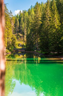 Dolomitler. Braies gölü ve tekneleri. Suda zümrüt renkleri.