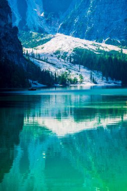 Dolomitler. Braies gölü ve tekneleri. Suda zümrüt renkleri.