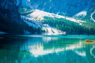 Dolomitler. Braies gölü ve tekneleri. Suda zümrüt renkleri.
