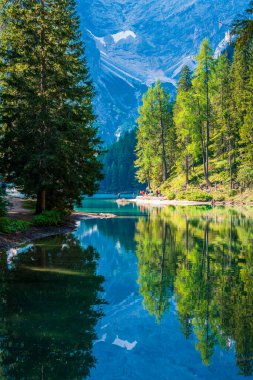 Dolomitler. Braies gölü ve tekneleri. Suda zümrüt renkleri.