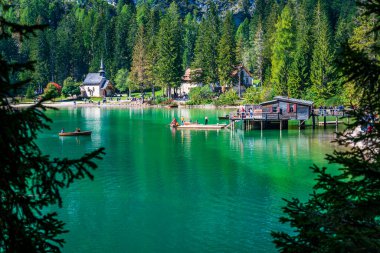 Dolomitler. Braies gölü ve tekneleri. Suda zümrüt renkleri.