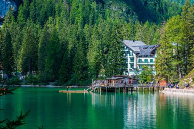 Dolomitler. Braies gölü ve tekneleri. Suda zümrüt renkleri.