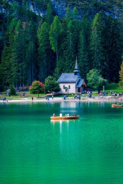 Dolomitler. Braies gölü ve tekneleri. Suda zümrüt renkleri.