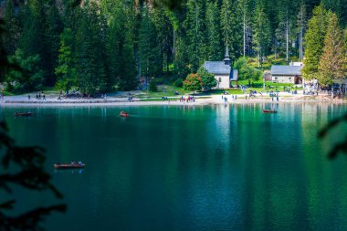 Dolomitler. Braies gölü ve tekneleri. Suda zümrüt renkleri.