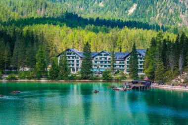 Dolomitler. Braies gölü ve tekneleri. Suda zümrüt renkleri.
