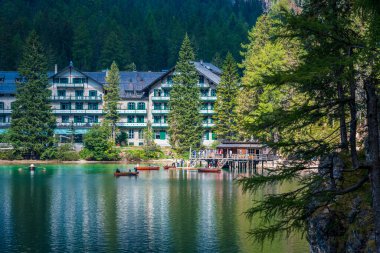 Dolomitler. Braies gölü ve tekneleri. Suda zümrüt renkleri.