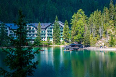 Dolomitler. Braies gölü ve tekneleri. Suda zümrüt renkleri.