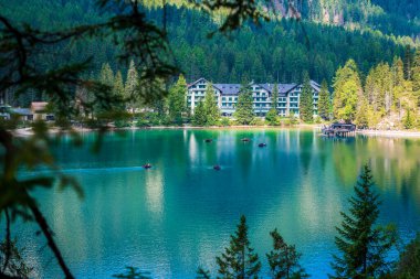 Dolomitler. Braies gölü ve tekneleri. Suda zümrüt renkleri.