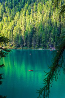 Dolomitler. Braies gölü ve tekneleri. Suda zümrüt renkleri.