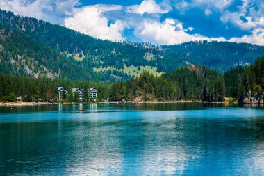 Dolomitler. Braies gölü ve tekneleri. Suda zümrüt renkleri.