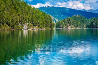 Dolomitler. Braies gölü ve tekneleri. Suda zümrüt renkleri.