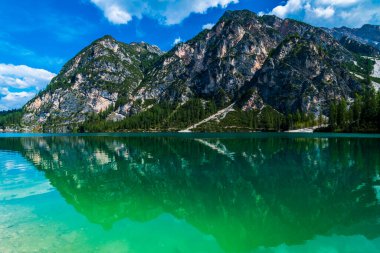 Dolomitler. Braies gölü ve tekneleri. Suda zümrüt renkleri.