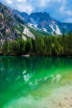 Dolomitler. Braies gölü ve tekneleri. Suda zümrüt renkleri.