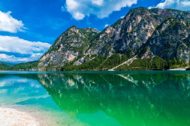 Dolomitler. Braies gölü ve tekneleri. Suda zümrüt renkleri.