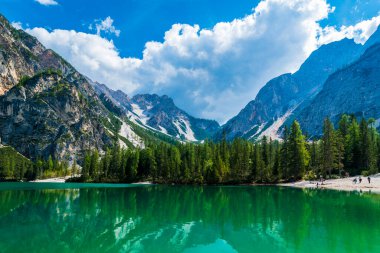 Dolomitler. Braies gölü ve tekneleri. Suda zümrüt renkleri.