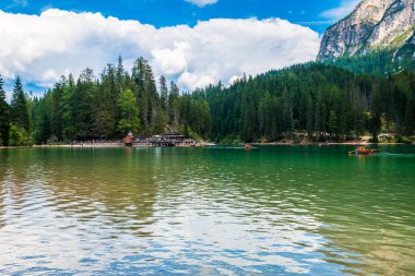 Dolomitler. Braies gölü ve tekneleri. Suda zümrüt renkleri.