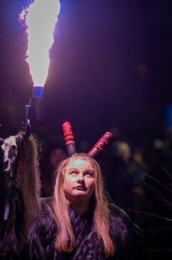 Tarvisio, İtalya - 8 Aralık 2022: İtalya 'da Pontebba gecesinde Krampus geleneksel gösterisinde iblis şeklinde bir kadın.