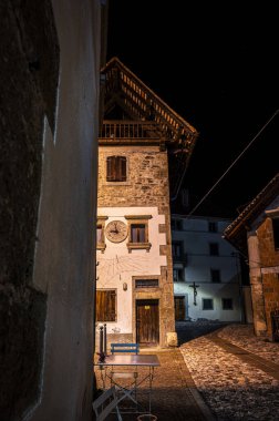 Pesariis, saat kasabası. Alacakaranlıkla gece arasında kasabada yürü.