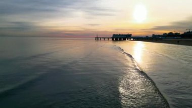 Lignano Sabbiadoro sahilinde gün batımı. Punta Faro rıhtımı ve Deniz Terası.