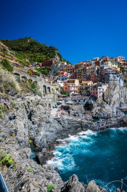 Kayalık sahil ve Manarola köyünün denize bakan güzel manzarası. Cinque Terre                    