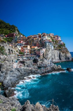 Kayalık sahil ve Manarola köyünün denize bakan güzel manzarası. Cinque Terre                    