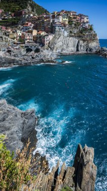 Kayalık sahil ve Manarola köyünün denize bakan güzel manzarası. Cinque Terre                    