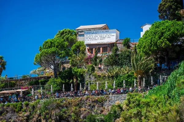 Güneşli yaz gününde kayalık deniz kıyısında yürüyen insanlar, Manarola, Cinque Terre, İtalya