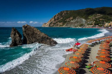 Deniz kıyısında dinlenen insanların güzel manzarası. Monterosso, liman, sahil ve antik köy.                    