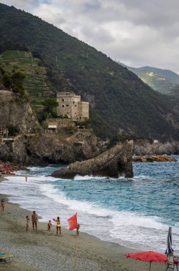 Deniz kıyısında dinlenen insanların güzel manzarası. Monterosso, liman, sahil ve antik köy.                    