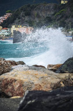 Dalgalar kayalık deniz kıyısına çarpıyor. Cinque Terre 'de. Monterosso, liman, sahil ve antik köy.                                  