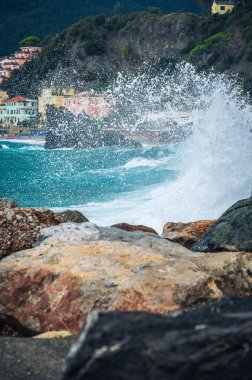 Dalgalar kayalık deniz kıyısına çarpıyor. Cinque Terre 'de. Monterosso, liman, sahil ve antik köy.                                  