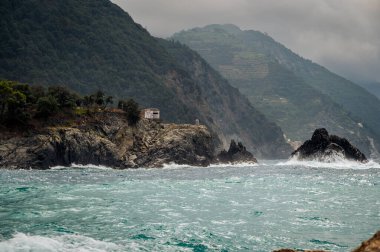 Dalgalar kayalık deniz kıyısına çarpıyor. Cinque Terre 'de. Monterosso, liman, sahil ve antik köy.                                  