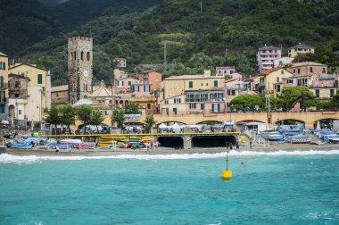 Deniz kıyısında dinlenen insanların güzel manzarası. Monterosso, liman, sahil ve antik köy.                    