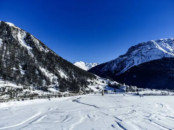 Reschensee 'deki (Resia Gölü) ünlü batık kilise kulesinin bulunduğu Alpler' deki kış manzarası Güney Tyrol (İtalyan Alpleri) ve Avusturya sınırı üzerindedir..