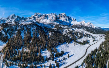 İtalyan Alplerinde karla kaplı dağlarla resmedilmiş kış manzarası.