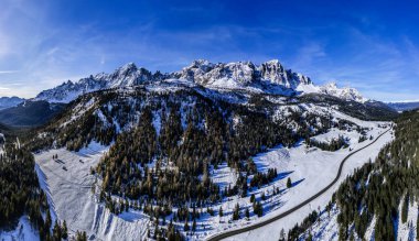 İtalyan Alplerinde karla kaplı dağlarla resmedilmiş kış manzarası.