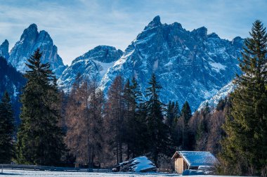 Val Fiscalina, Güney Tyrol 'da karla kaplı dağ tepesindeki ahşap ev manzarası