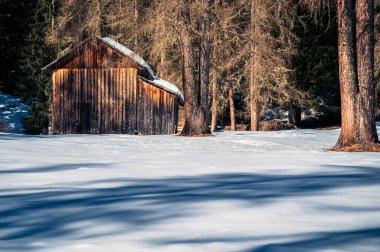 Val Fiscalina, Güney Tyrol 'da karla kaplı dağ tepesindeki ahşap ev manzarası