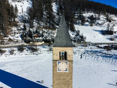 View of the ancient bell tower of Curon Venosta on Lake Resia clipart