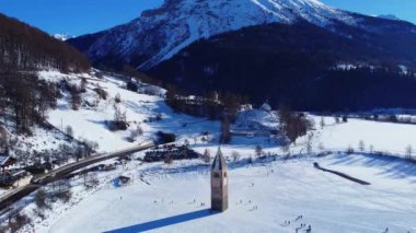 Resia Gölü 'nde kış ve eski Curon köyünün muhteşem ıssız çan kulesi Val Venosta.