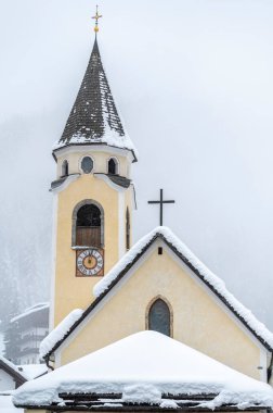 Sappada, Veneto, İtalya 'da kış aylarında yapılan kar yağışı sırasında kilise 